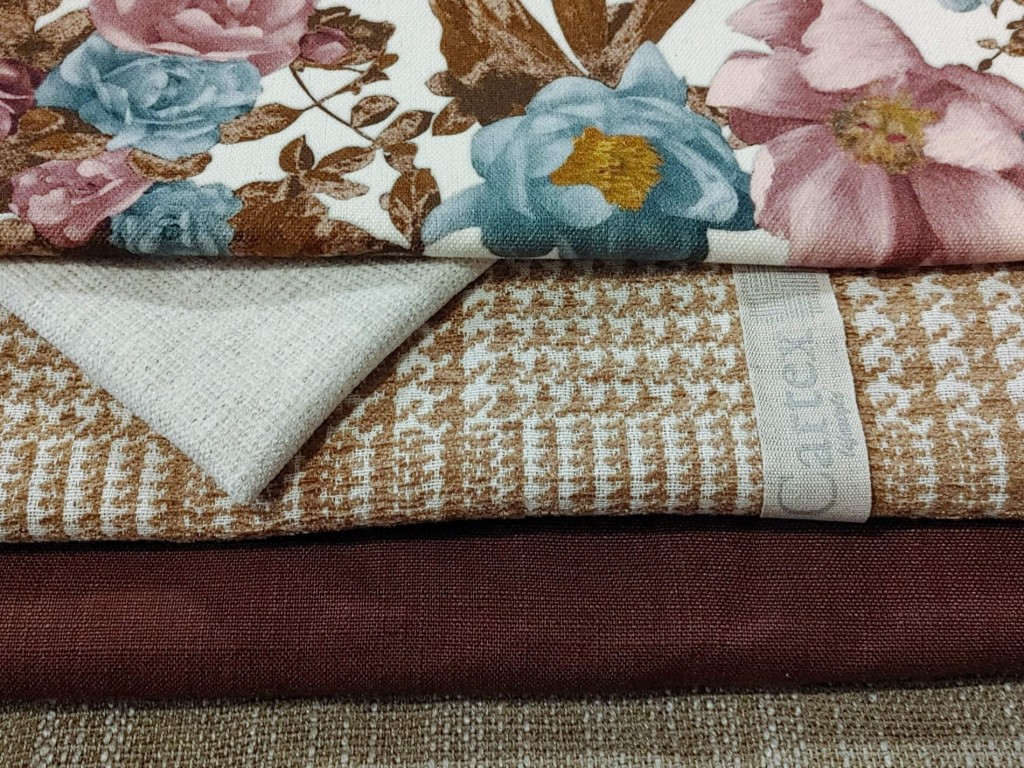 Various floral and unfolded fabrics arranged on top of each other