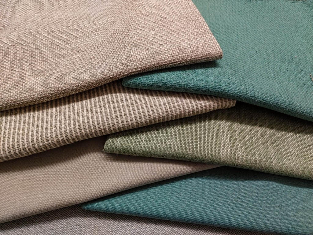 composition of six sofa fabrics in soft colours folded and overlapped