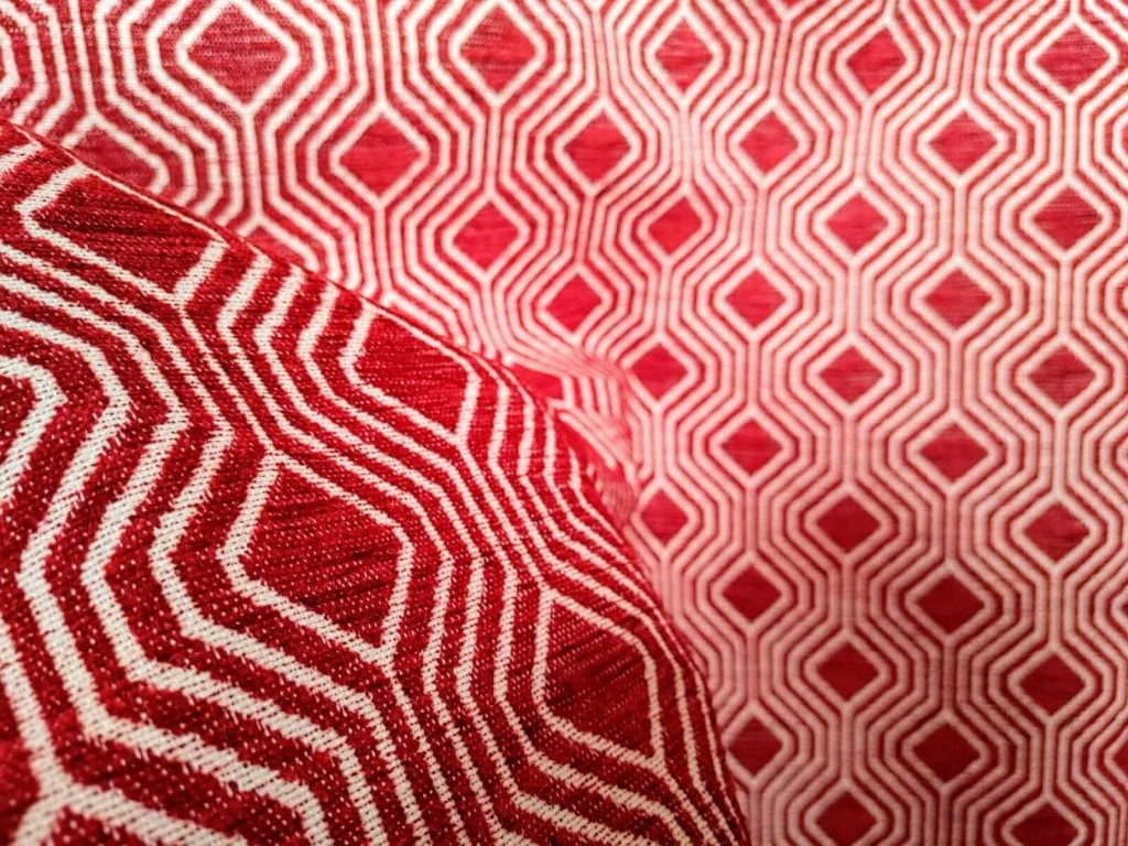 Tessuto per arredamento con pattern geometrico bianco su fondo rosso